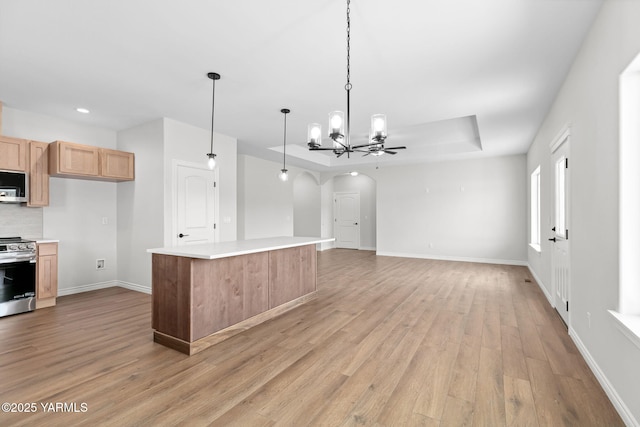 4608 W Larch Ave, Yakima, WA 98908 - kitchen with stainless steel appliances, arched walkways, light brown cabinetry, light wood-type flooring, and light countertops