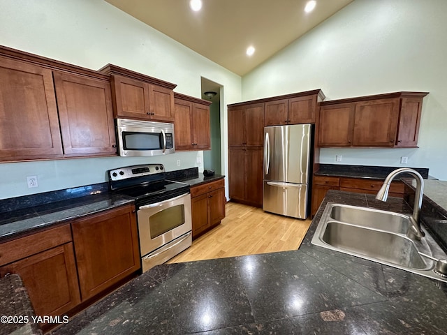 1010 S 89th Ave, Yakima, WA 98908 - kitchen featuring stainless steel appliances, a sink, vaulted ceiling, recessed lighting, and dark countertops