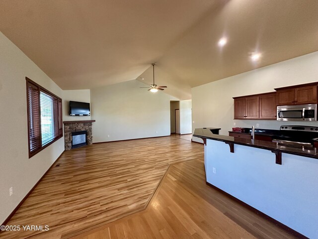 1010 S 89th Ave, Yakima, WA 98908 - kitchen with appliances with stainless steel finishes, a breakfast bar, light wood-type flooring, open floor plan, and a ceiling fan