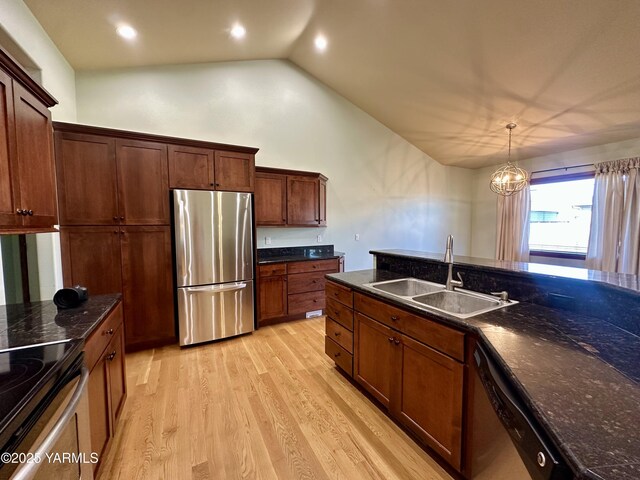 1010 S 89th Ave, Yakima, WA 98908 - kitchen featuring stainless steel appliances, a sink, lofted ceiling, light wood-style floors, and dark stone counters