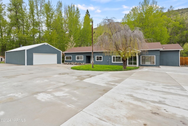 view of front of home with a detached garage, a front lawn, and an outdoor structure