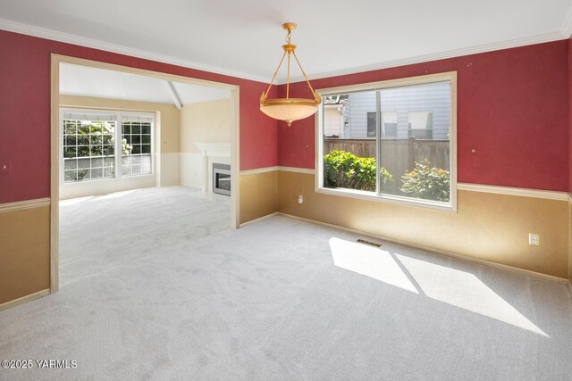 23812 21st Dr Unit Se, Bothell, WA 98021 - empty room featuring a glass covered fireplace, carpet floors, crown molding, and visible vents