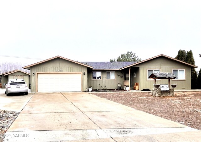 ranch-style house with an attached garage, driveway, and a shingled roof