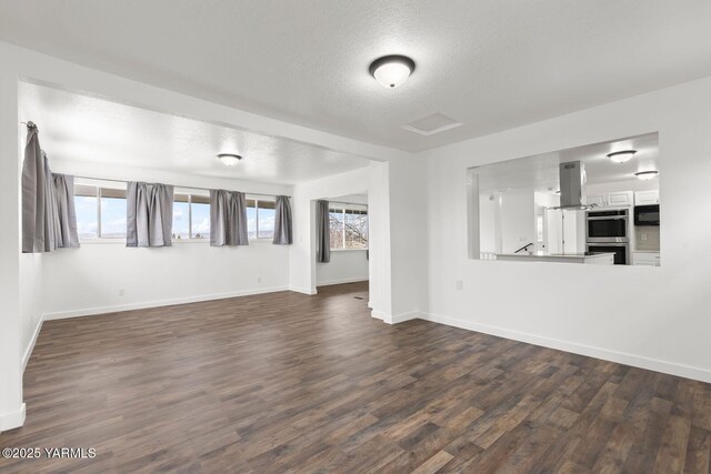 12307 Tieton Dr, Yakima, WA 98908 - unfurnished living room featuring dark wood finished floors, baseboards, plenty of natural light, and a textured ceiling