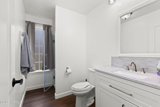 12307 Tieton Dr, Yakima, WA 98908 - bathroom with wood finished floors, backsplash, baseboards, toilet, and vanity