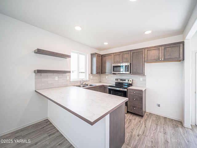 4700 W Oak Ave, Yakima, WA 98903 - kitchen featuring stainless steel appliances, open shelves, a sink, a peninsula, and light countertops