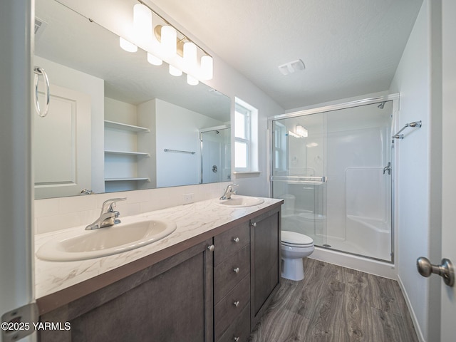 4700 W Oak Ave, Yakima, WA 98903 - full bathroom featuring wood finished floors, toilet, a shower stall, double vanity, and a textured ceiling