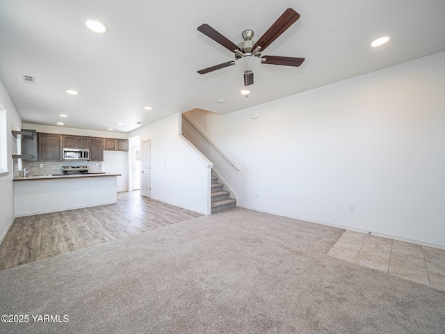 4700 W Oak Ave, Yakima, WA 98903 - unfurnished living room with recessed lighting, stairway, ceiling fan, light carpet, and a sink