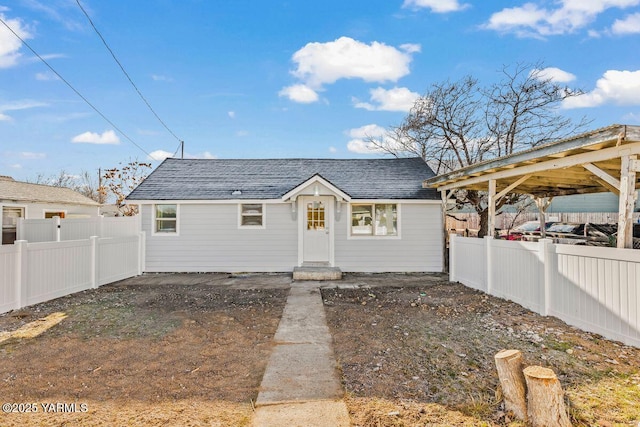 view of front of property with a shingled roof and a fenced backyard