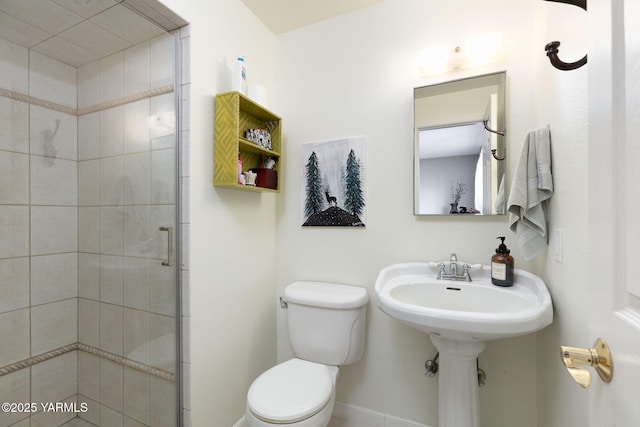 full bathroom featuring toilet, a stall shower, and baseboards