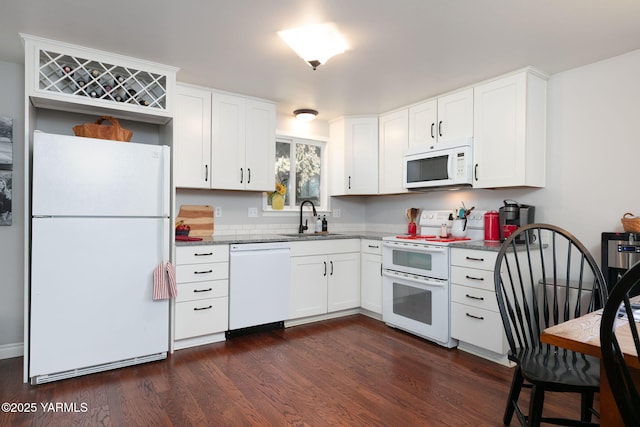 kitchen with white cabinets, white appliances, dark wood finished floors, and a sink