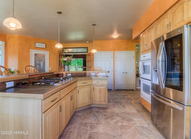 11901 Zier Rd, Yakima, WA 98908 - kitchen with appliances with stainless steel finishes, light brown cabinets, decorative light fixtures, and dark countertops