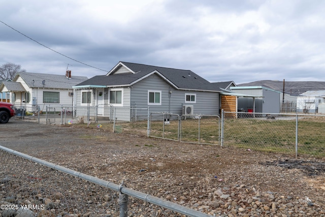 view of front of home with a fenced front yard, a gate, and a shingled roof