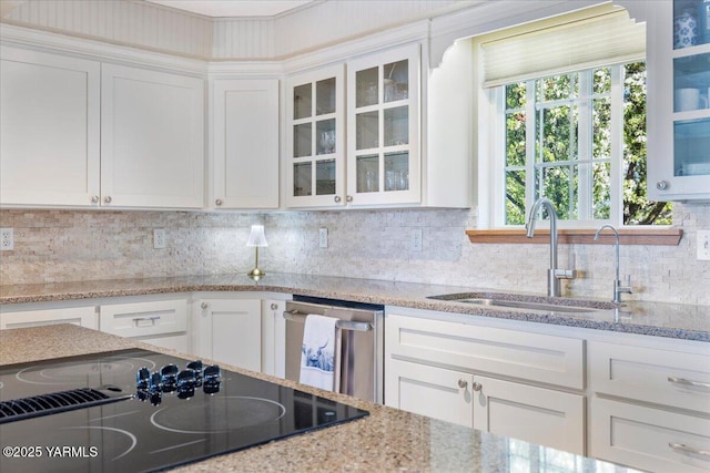 10401 N 1739th Pr NW, Grandview, WA 98930 - kitchen featuring stainless steel dishwasher, a sink, white cabinetry, glass insert cabinets, and light stone countertops