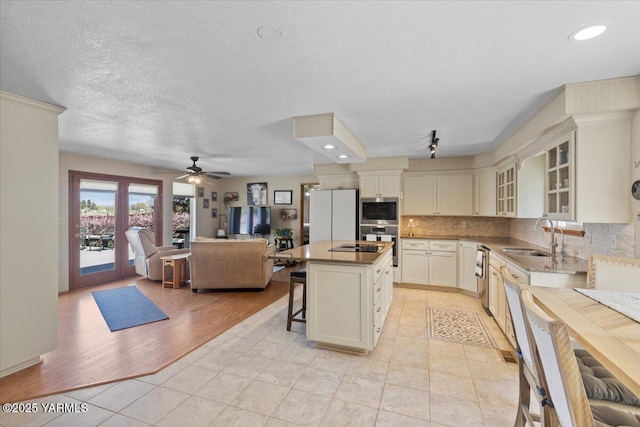 10401 N 1739th Pr NW, Grandview, WA 98930 - kitchen featuring tasteful backsplash, a sink, a kitchen bar, appliances with stainless steel finishes, and a kitchen island