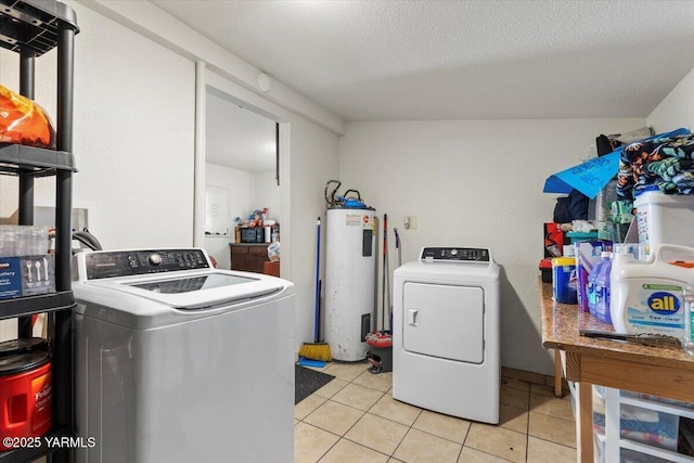 laundry area featuring laundry area, water heater, washer and clothes dryer, and light tile patterned floors