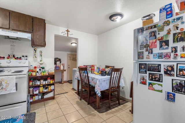 dining area with light tile patterned floors and a textured ceiling