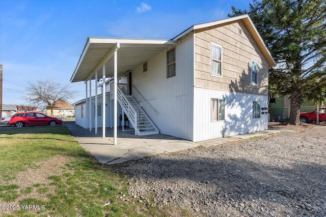 exterior space featuring stairs and a front lawn