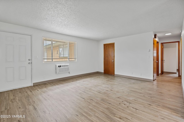 904 S 42nd Ave Unit A, B, C, D, Yakima, WA 98908 - unfurnished living room with a wall mounted AC, a textured ceiling, and light wood finished floors