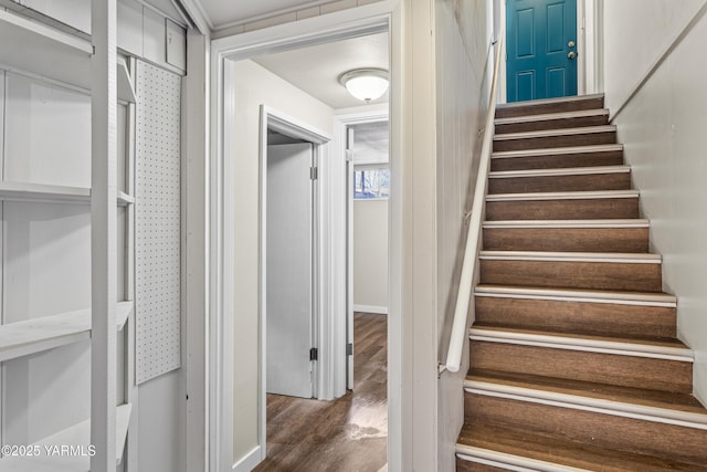 staircase with baseboards and wood finished floors