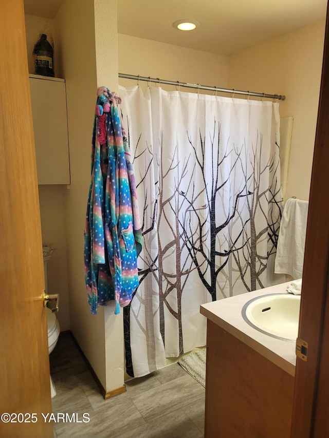 full bathroom featuring toilet, wood finished floors, a shower with shower curtain, and vanity