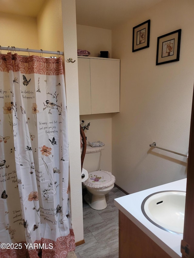 bathroom with toilet, curtained shower, and vanity