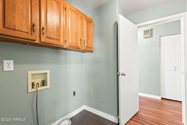clothes washing area with cabinet space, electric dryer hookup, baseboards, and washer hookup