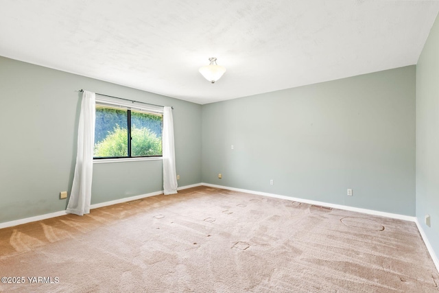 carpeted empty room with baseboards