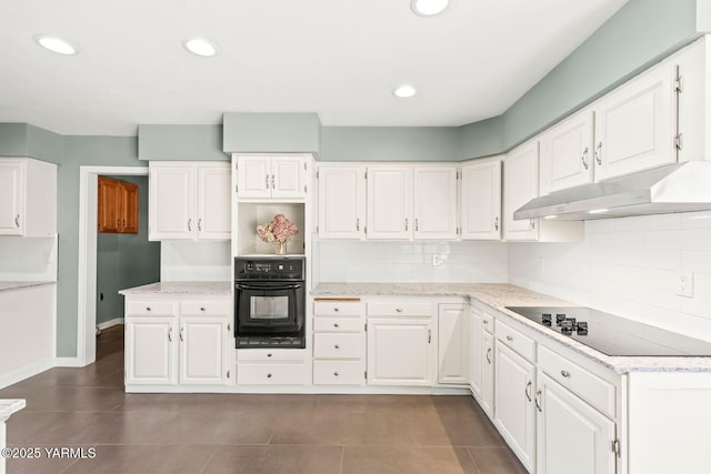 kitchen featuring white cabinets, under cabinet range hood, and black appliances