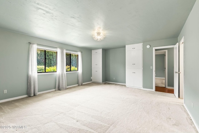 unfurnished bedroom with baseboards and light carpet