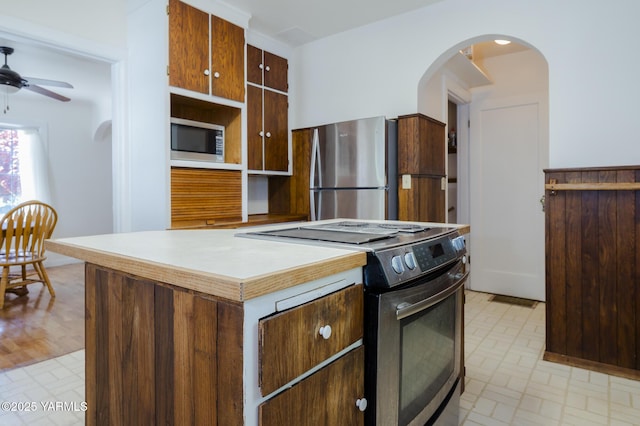 418 S 32nd Ave, Yakima, WA 98902 - kitchen featuring appliances with stainless steel finishes, arched walkways, a ceiling fan, and brick patterned floors
