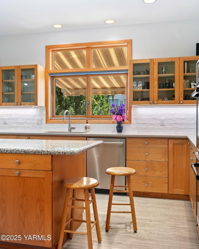 1011 N 79th Ave, Yakima, WA 98908 - kitchen featuring stainless steel dishwasher, a sink, backsplash, glass insert cabinets, and recessed lighting