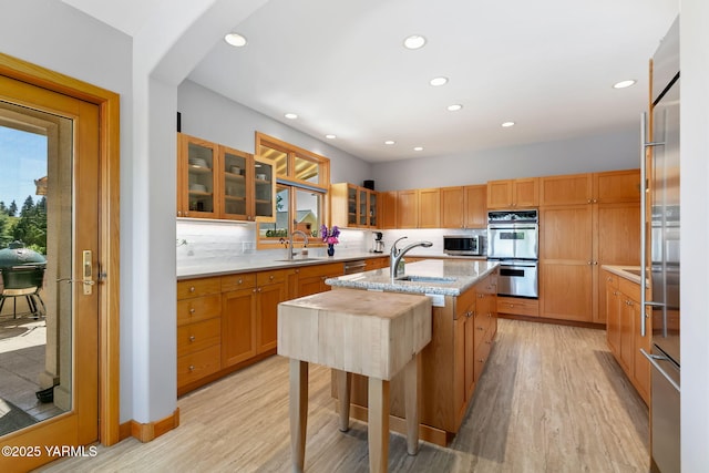 1011 N 79th Ave, Yakima, WA 98908 - kitchen with stainless steel appliances, a sink, light wood finished floors, an island with sink, and recessed lighting