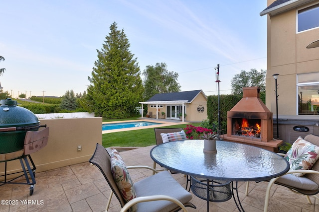 1011 N 79th Ave, Yakima, WA 98908 - view of patio with a lit fireplace, an exterior structure, an outbuilding, and an outdoor pool