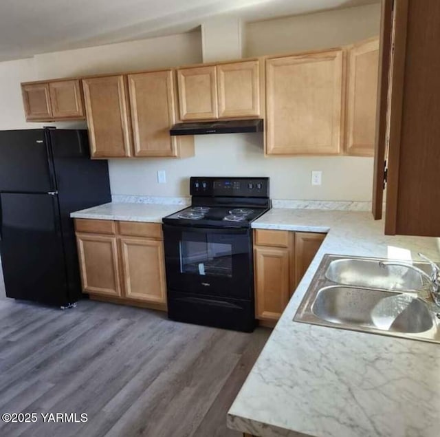 kitchen featuring black appliances, under cabinet range hood, a sink, and light countertops