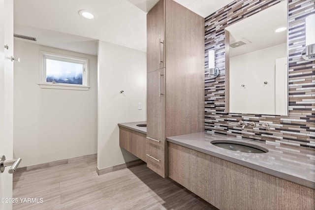 5902 Glacier Way, Yakima, WA 98908 - bathroom with decorative backsplash, vanity, baseboards, recessed lighting, and wood finished floors