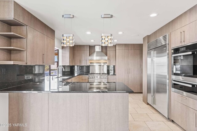 5902 Glacier Way, Yakima, WA 98908 - kitchen with high quality appliances, wall chimney range hood, a peninsula, dark stone countertops, and recessed lighting