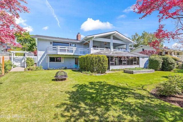 5902 Glacier Way, Yakima, WA 98908 - rear view of house with an outdoor fire pit, a chimney, a gate, a sunroom, and a balcony