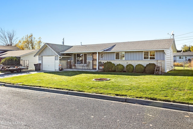 single story home featuring board and batten siding, concrete driveway, brick siding, and a front lawn