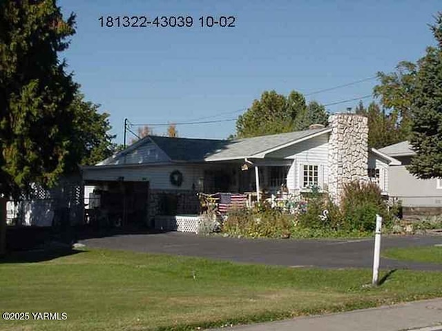 view of front of home featuring aphalt driveway, a front lawn, and an attached garage