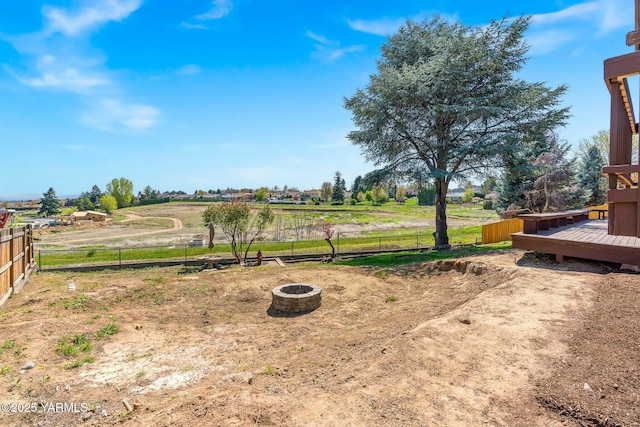 view of yard with a fire pit, fence, and a deck