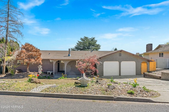 single story home featuring a garage, driveway, and stucco siding
