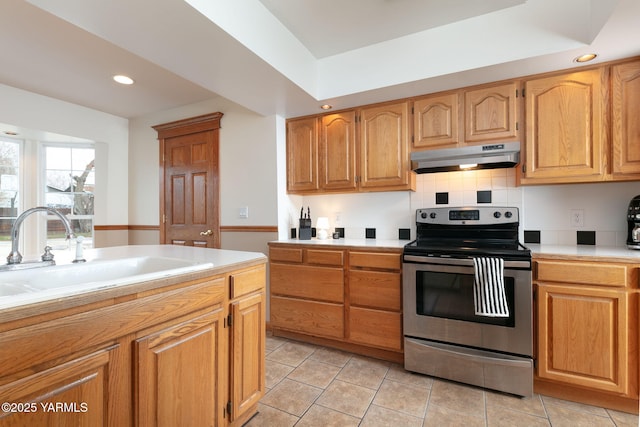 3703 W Chestnut Ave, Yakima, WA 98902 - kitchen featuring stainless steel range with electric stovetop, under cabinet range hood, a sink, light countertops, and light tile patterned flooring