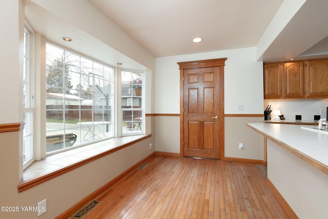 3703 W Chestnut Ave, Yakima, WA 98902 - kitchen with light wood-style flooring, baseboards, brown cabinetry, recessed lighting, and tile counters