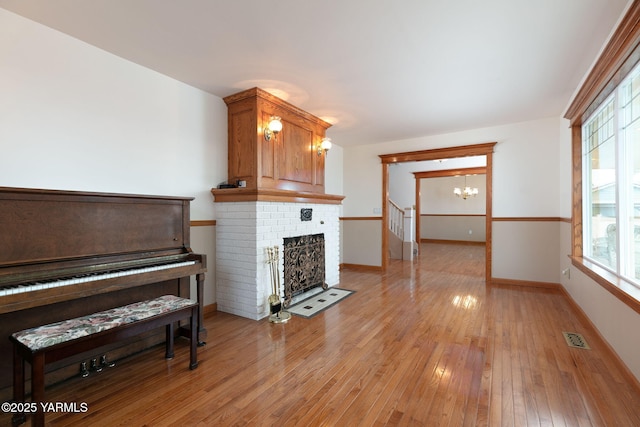 3703 W Chestnut Ave, Yakima, WA 98902 - living room featuring a chandelier, healthy amount of natural light, light wood-style floors, and baseboards
