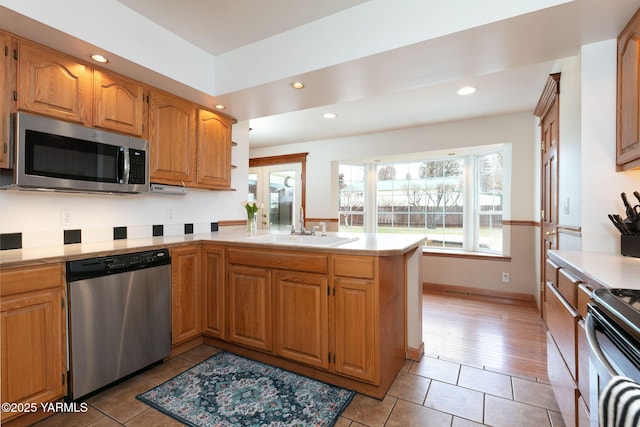 3703 W Chestnut Ave, Yakima, WA 98902 - kitchen featuring stainless steel appliances, a sink, a peninsula, light countertops, and light tile patterned floors