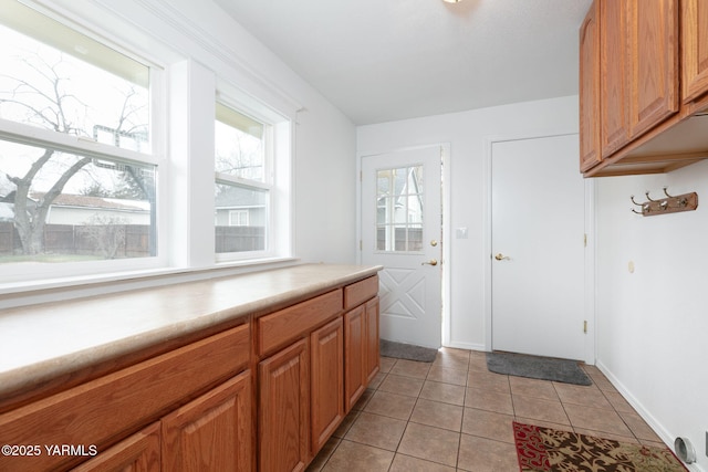 entryway with light tile patterned floors and baseboards