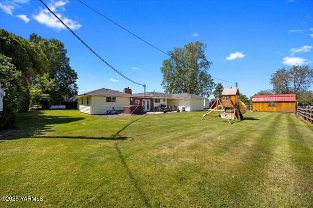 3700 Sheller Rd, Sunnyside, WA 98944 - view of grassy yard with a playground, a storage unit, an outdoor structure, and a garage