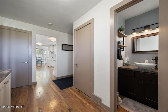 3700 Sheller Rd, Sunnyside, WA 98944 - corridor with a sink, dark wood-style floors, and baseboards