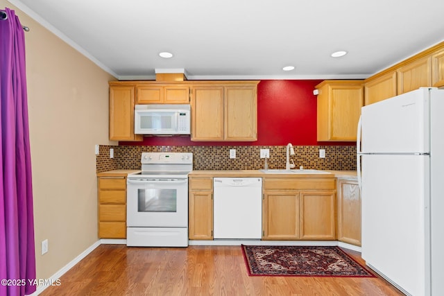 kitchen featuring white appliances, a sink, decorative backsplash, light countertops, and light wood-type flooring